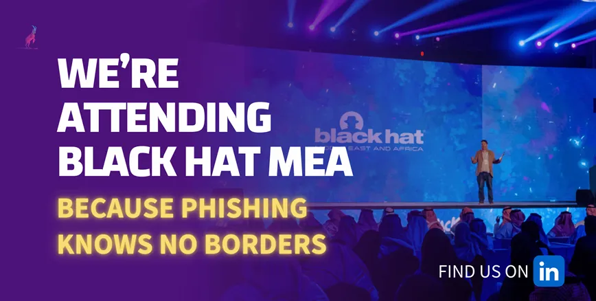 Banner "We're attending Black Hat MEA – because phishing knows no borders" over a speaker on the Black Hat stage.